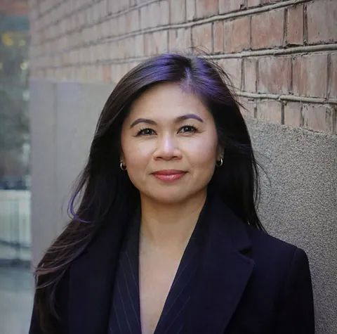 Regnskapsfører Nhung Hguyen, med langt mørkt hår og svart dress